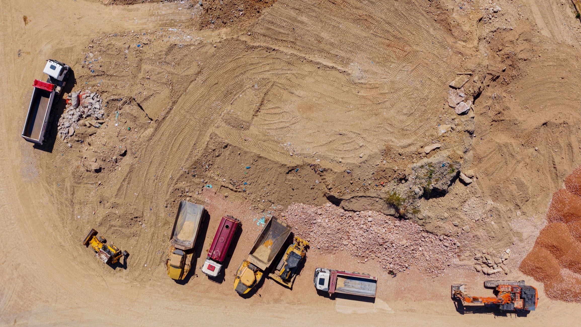 Active construction site with heavy machinery and dump trucks