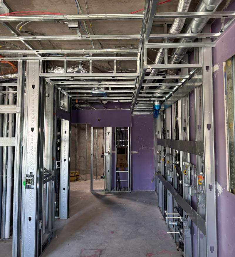 Interior view of light-gauge metal framing for walls and ceiling in a multifamily construction project